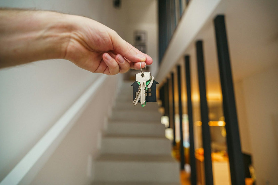 A set of house keys held in the hallway of a new home