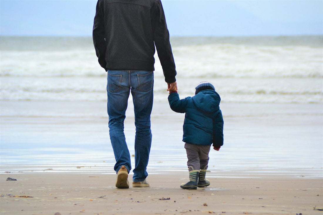 A father and son walking along a beach