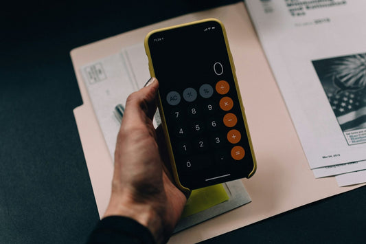 A calculator and notepad being used to work out a household budget