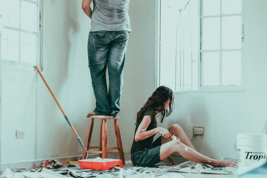 A couple painting a wall in their new home