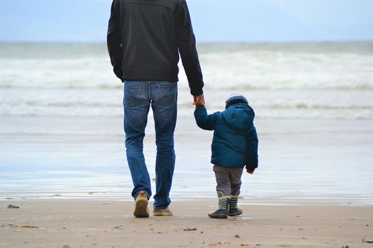 A father and son walking along a beach