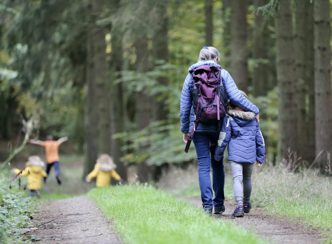 A mother walking through a park with her children