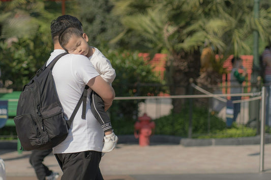 A parent carrying a sleeping child